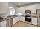 Functional kitchen featuring stainless steel appliances, white cabinets, and tile flooring at 727 Torrey Pines Ln, Fort Mill, SC 29715