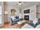 Cozy living room with a fireplace, hardwood floors, comfortable seating and a large television at 727 Torrey Pines Ln, Fort Mill, SC 29715