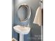 Stylish powder room with a pedestal sink, silver-framed mirror, and a fresh white towel at 727 Torrey Pines Ln, Fort Mill, SC 29715