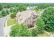 Expansive aerial view of a brick two-story home surrounded by lush greenery and a manicured lawn at 8409 Olde Stonegate Ln, Mint Hill, NC 28227