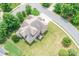 Aerial view of a large brick home with a well-manicured lawn and mature trees at 8409 Olde Stonegate Ln, Mint Hill, NC 28227
