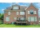 A view of the rear brick exterior and fenced back yard with a deck at 8409 Olde Stonegate Ln, Mint Hill, NC 28227