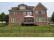 Backyard view featuring an outdoor deck and grassy lawn with a wrought iron fence at 8409 Olde Stonegate Ln, Mint Hill, NC 28227