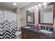 Well-lit bathroom with double vanity, dark cabinets, and tiled floors, offering a clean and functional space at 8409 Olde Stonegate Ln, Mint Hill, NC 28227