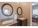 Stylish bathroom with double sinks, granite countertops, round mirrors, and plenty of light at 8409 Olde Stonegate Ln, Mint Hill, NC 28227