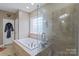 Luxurious bathroom featuring a large soaking tub and a separate glass-enclosed shower at 8409 Olde Stonegate Ln, Mint Hill, NC 28227