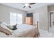 Bright bedroom with a wooden bed frame, ceiling fan, and a window offering ample natural light at 8409 Olde Stonegate Ln, Mint Hill, NC 28227