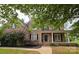 Beautiful brick home featuring black shutters and a covered porch at 8409 Olde Stonegate Ln, Mint Hill, NC 28227
