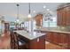 Open-concept kitchen boasts an island with seating, wooden cabinetry, and a seamless flow to the dining area at 8409 Olde Stonegate Ln, Mint Hill, NC 28227
