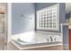 Bright bathroom with a soaking tub, with a glass block window providing natural light and privacy at 9429 Ridgeforest Dr, Charlotte, NC 28277