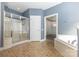 Bright bathroom with a tiled floor, glass enclosed shower, and separate soaking tub for ultimate relaxation at 9429 Ridgeforest Dr, Charlotte, NC 28277