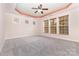 Spacious bedroom with tray ceiling, ceiling fan, carpet, and windows at 9429 Ridgeforest Dr, Charlotte, NC 28277
