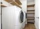 Large laundry room with washer, dryer, and plenty of shelving for storage at 9429 Ridgeforest Dr, Charlotte, NC 28277
