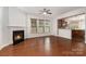 An open-concept living space showcases hardwood floors, fireplace, and seamless connection to kitchen area at 9429 Ridgeforest Dr, Charlotte, NC 28277