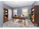Stylish home office featuring built-in bookshelves, a modern desk, and large windows with bright natural light at 9429 Ridgeforest Dr, Charlotte, NC 28277