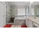 Beautiful bathroom with a tiled shower, soaking tub, vanity, and modern fixtures at 10924 Owl Nest Ln, Charlotte, NC 28277