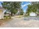 Spacious backyard with gravel area, mature trees, and a shed at 1112 Concord Ave, Monroe, NC 28110