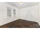 Inviting bedroom with hardwood floors, white walls, and natural light streaming through two windows at 1112 Concord Ave, Monroe, NC 28110