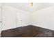 Stylish bedroom featuring hardwood floors, white walls, and a modern light fixture at 1112 Concord Ave, Monroe, NC 28110