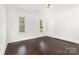 Inviting bedroom with hardwood floors, a modern light fixture, and dual windows providing natural light at 1112 Concord Ave, Monroe, NC 28110