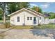 Charming home exterior featuring light yellow siding, blue door, and a well-maintained yard at 1112 Concord Ave, Monroe, NC 28110