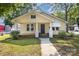 Charming yellow bungalow featuring a covered front porch, landscaped yard, and inviting curb appeal at 1112 Concord Ave, Monroe, NC 28110
