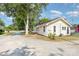 Quaint home exterior featuring light yellow siding, black roof, and a gravel driveway at 1112 Concord Ave, Monroe, NC 28110