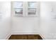 Small room illuminated by two windows, complemented by dark wood floors and white walls at 1112 Concord Ave, Monroe, NC 28110
