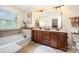 Bathroom featuring double sinks, soaking tub, and decorative tiling at 1126 Roderick Dr, Fort Mill, SC 29708