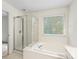 Bright bathroom features a shower and soaking tub combination with a window at 12529 Old Timber Rd, Charlotte, NC 28269