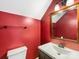 Bathroom featuring a single sink vanity with a framed mirror and red walls at 12529 Old Timber Rd, Charlotte, NC 28269