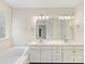 Bathroom featuring double sink vanity, large soaking tub, and great natural light at 12529 Old Timber Rd, Charlotte, NC 28269