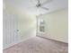 Bedroom featuring a ceiling fan, plush carpet, and a window view at 12529 Old Timber Rd, Charlotte, NC 28269
