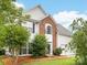 Two-story home with brick and siding exterior, lush landscaping, and a well-maintained front lawn at 12529 Old Timber Rd, Charlotte, NC 28269