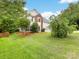 View of the front yard with green grass and red mulch and a partial view of the house at 12529 Old Timber Rd, Charlotte, NC 28269