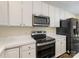 Well-lit kitchen features stainless steel appliances, including a microwave and a smooth top range at 12529 Old Timber Rd, Charlotte, NC 28269