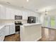 Well-lit kitchen featuring white cabinets, stainless steel appliances, and peninsula at 12529 Old Timber Rd, Charlotte, NC 28269