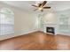 Bright living room featuring a fireplace, hardwood floors, and large windows at 12529 Old Timber Rd, Charlotte, NC 28269