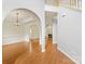 Open-concept living room with hardwood floors, arched doorways, and lots of natural light from the fireplace at 12529 Old Timber Rd, Charlotte, NC 28269