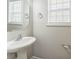 Bright pedestal sink in a bathroom with a framed mirror and natural light at 13413 Golden Apple Ct, Charlotte, NC 28215