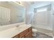 Well-lit bathroom featuring a wood vanity sink and a tub-shower combo at 13413 Golden Apple Ct, Charlotte, NC 28215