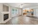 An open concept living room with a fireplace and modern gray flooring flowing to the kitchen at 13413 Golden Apple Ct, Charlotte, NC 28215