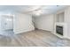 Spacious living room with a fireplace, gray floors, a staircase, and neutral wall paint at 13413 Golden Apple Ct, Charlotte, NC 28215