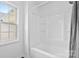 Bright bathroom featuring a white shower-tub combination and a window at 1377 Beagle Run, Salisbury, NC 28146