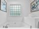 Bright bathroom showcasing a tiled window above a soaking tub with elegant fixtures and neutral decor at 1377 Beagle Run, Salisbury, NC 28146