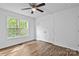 Bright bedroom showcases laminate flooring, a ceiling fan, a window, and a spacious closet, offering comfort and style at 1377 Beagle Run, Salisbury, NC 28146