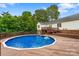 Above ground pool with a wooden deck and a lush green backdrop at 1377 Beagle Run, Salisbury, NC 28146