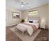 Staged bedroom showcasing bed, bedside tables and lamps, and neutral walls and carpet at 1556 Walnut View Dr, Charlotte, NC 28208