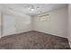 Spacious, carpeted bedroom featuring a ceiling fan, a window and a white door at 1556 Walnut View Dr, Charlotte, NC 28208