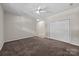 Unfurnished carpeted bedroom featuring a ceiling fan and a closet with folding doors at 1556 Walnut View Dr, Charlotte, NC 28208